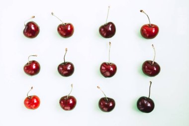 Işıklı arka planda parlak kırmızı kiraz. Kiraz deseni. Kirazlar yakın plan. Yaz yassı böğürtlen arka planı. Üst görünüm