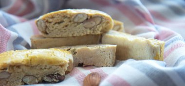 Çizgili mutfak havlusunda tatlı bisküvi ve badem. Yan görünüm