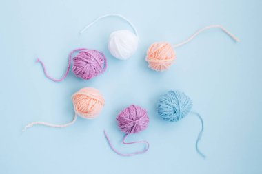 Birkaç renkli iplik izi, açık mavi arkaplan üzerinde fotokopi alanı olan bir daire şeklinde düzenlenmiştir. Kapat.