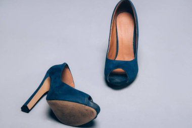 Kadınların mavi ayakkabıları, gri arka planda yüksek topuklar. Parti sonrası moda konsepti. Yan görünüm