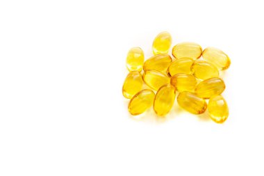 Beyaz arka planda izole edilmiş parlak sarı balık yağı kapsülleri. E vitamini. Metnin için uzayı kopyala