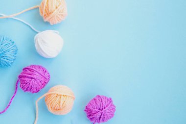 Açık mavi arkaplanda kopyalama alanı olan çeşitli renkli iplikler