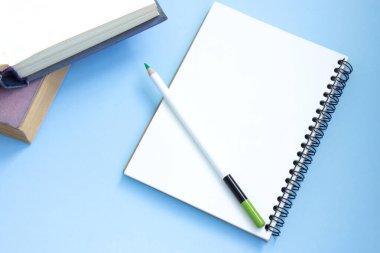 Defteri ve kalemi açık renkli ciltli kitaplar yığını. Online eğitim. Üst görünüm