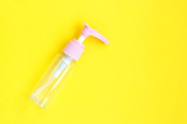 Boş pompa, krem, şampuan ve parlak sarı kağıttan arkaplan serumu için temiz plastik kaplar. Plastik portatif krema kavanozu ya da sıvı kabın üst görüntüsü. Kapat.