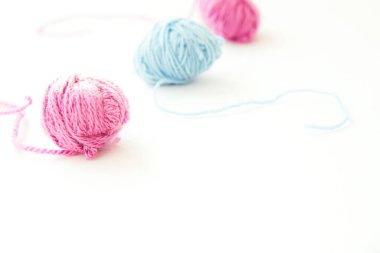 Fotokopi aletiyle birlikte açık arkaplanda üç adet çok renkli yün iplik. Kapat.