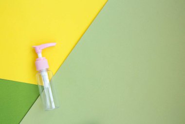 Krem, şampuan ve doğal arka plan serumu için kozmetik kavanozunu taklit et. Sarı yeşil arka plan. Boş plastik taşınabilir krem kavanozu ve sıvı kabın üst görünümü