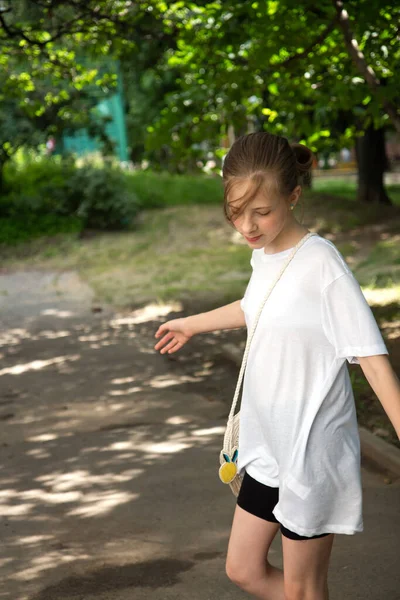 Krásná puberťačka chodí po parku. Procházka v přírodě v létě — Stock fotografie