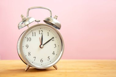 Parlak açık pembe arkaplanda fotokopi alanı olan bir çalar saat. Zaman kavramı