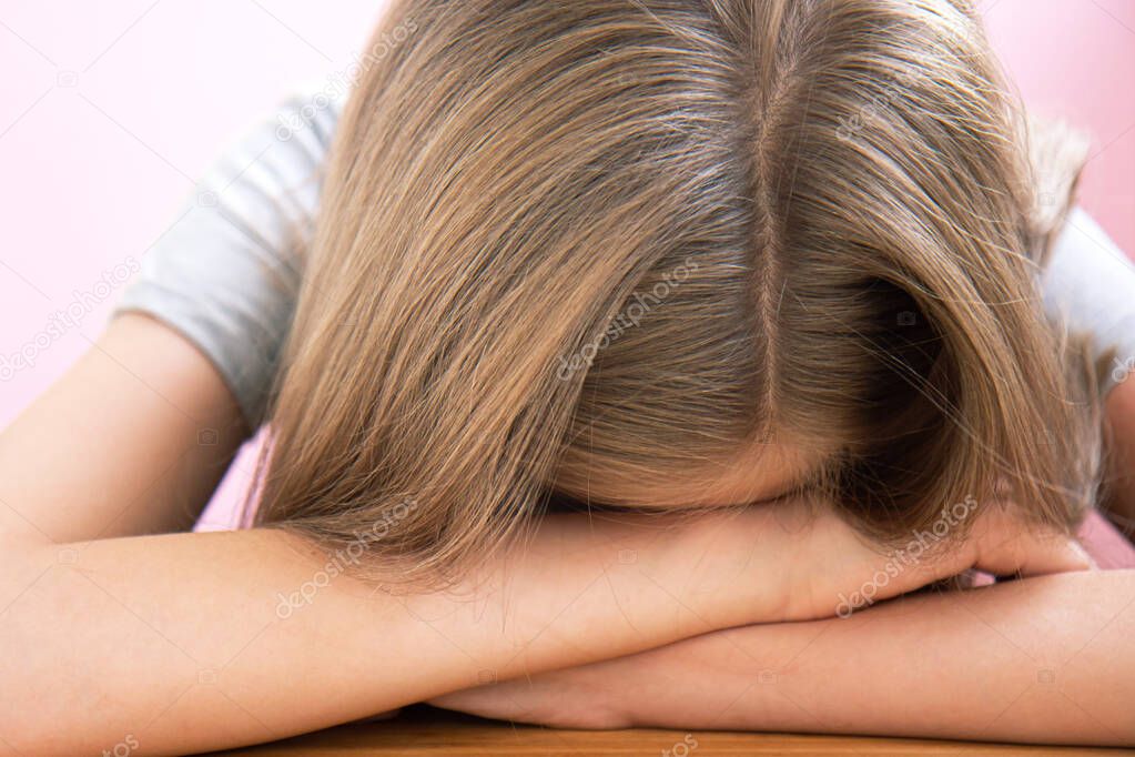 Tired student preparing for exams on light pink background with copy space