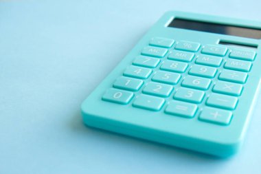 Mint hesap makinesi, defter ve kalem mavi arkaplanda izole edilmiş. Aile bütçesi kavramı, yatırımlar