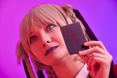 Renkli bir arkaplanda elinde iskambil kağıtları olan kız