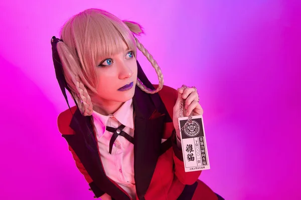 Kırmızı ceketli kız renkli bir arka planda işaret tutuyor.