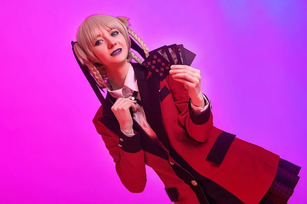 Girl with playing cards in hands on a colored background