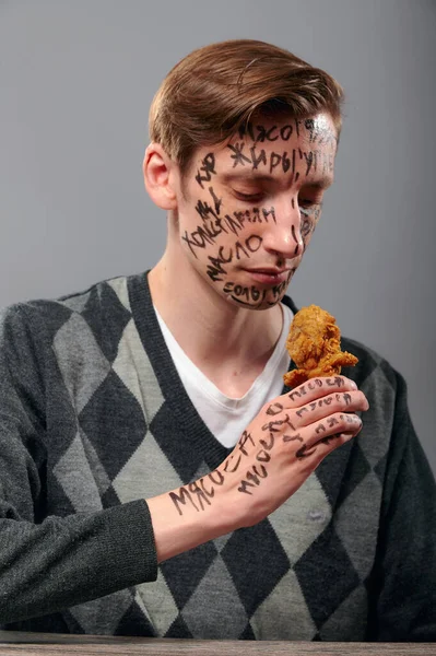 Üzgün adam tavuk bacağına bakıyor ve diyeti düşünüyor.