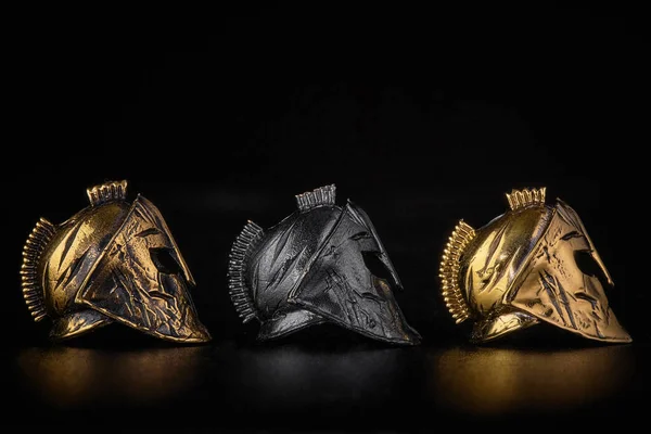 Siyah arka planda altın, bronz ve metal Sparta miğferi