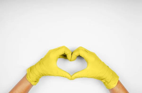 Handen Gele Hartvormige Medische Handschoenen Grijze Achtergrond Stockfoto