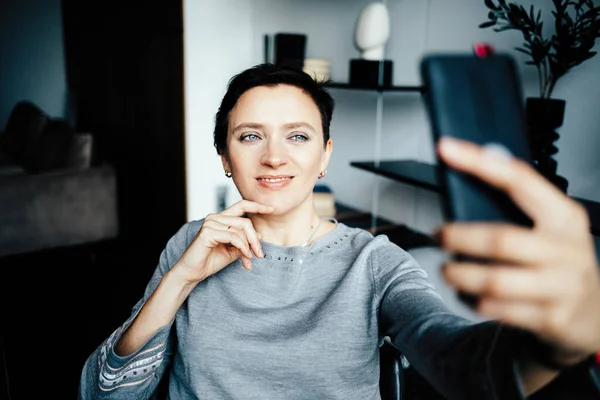 Cep telefonlu bir kadın kuryeyle uzaktan konuşma yapar.