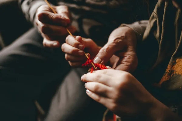 Grandmother teaches to knit granddaughter