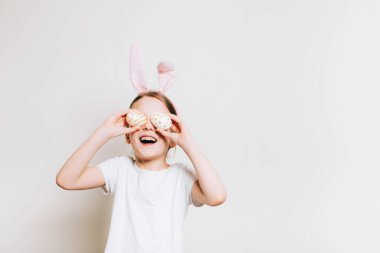 Tavşan kostümlü çocuk ve eğlence zamanı. Komik tavşan kulağı takan sevimli bir kız. Paskalya bahar tatili