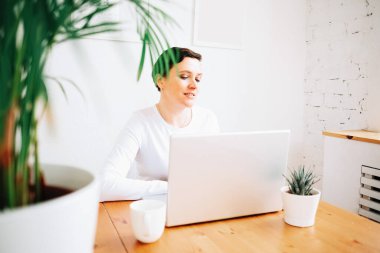 Bir kadın, karantina sırasında uzaktan bilgisayarla evde çalışıyor.