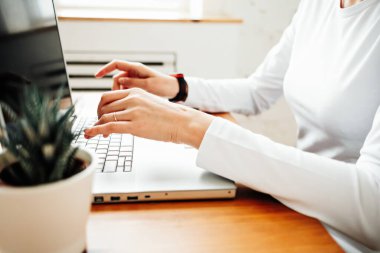 Dizüstü bilgisayarda çalışan bir kadın.