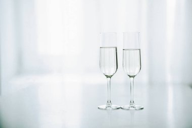 Two glasses of champagne in the background of the window clipart