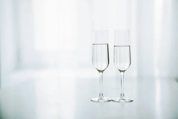 Twee glazen champagne op de achtergrond van het raam Stockfoto