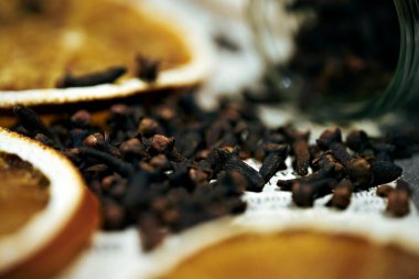 Defocused background with dry orange slices and cloves. Close up
