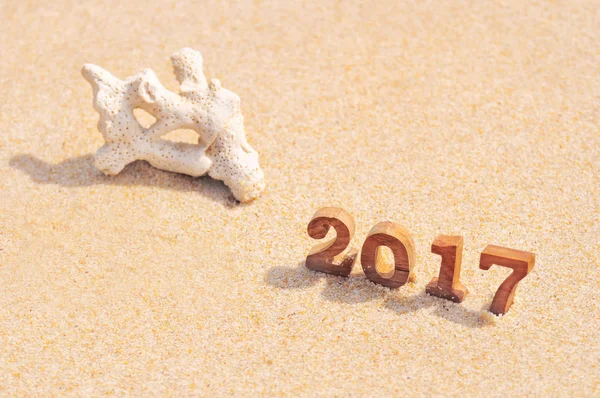 Wood number 2017 with white coral on tropical beach background — Stock Photo, Image