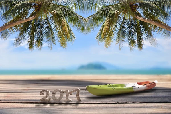 Wood number 2017 with kayak on planks on tropical beach background — Stock Photo, Image