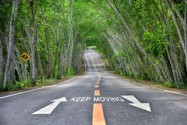 Mots de continuer à se déplacer avec la flèche blanche et le marquage de ligne jaune sur la route — Photo