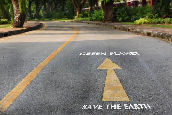Palabras de salvar la tierra y el planeta verde en la superficie de la carretera — Foto de Stock