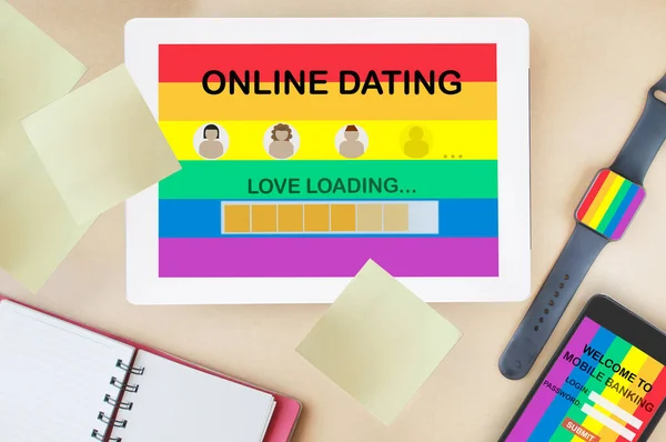 LGBTQ online dating and financial technology concept and digital transformation idea . Online dating application on computer digital tablet screen and mobile banking fintech on smart phone on colorful rainbow background.