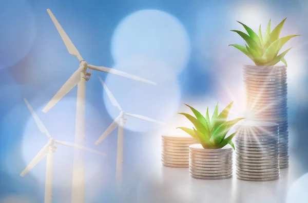 Renewable clean energy investment for sustainability  concept and alternative energy economic growth idea. Growing money plant on stack of coins and arrow with turbine and power background