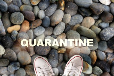 Taşların üzerine beyaz ayakkabıyla karantina yazılmış. Yönlendirme fikriyle yeni normal karar kavramı ve başarı