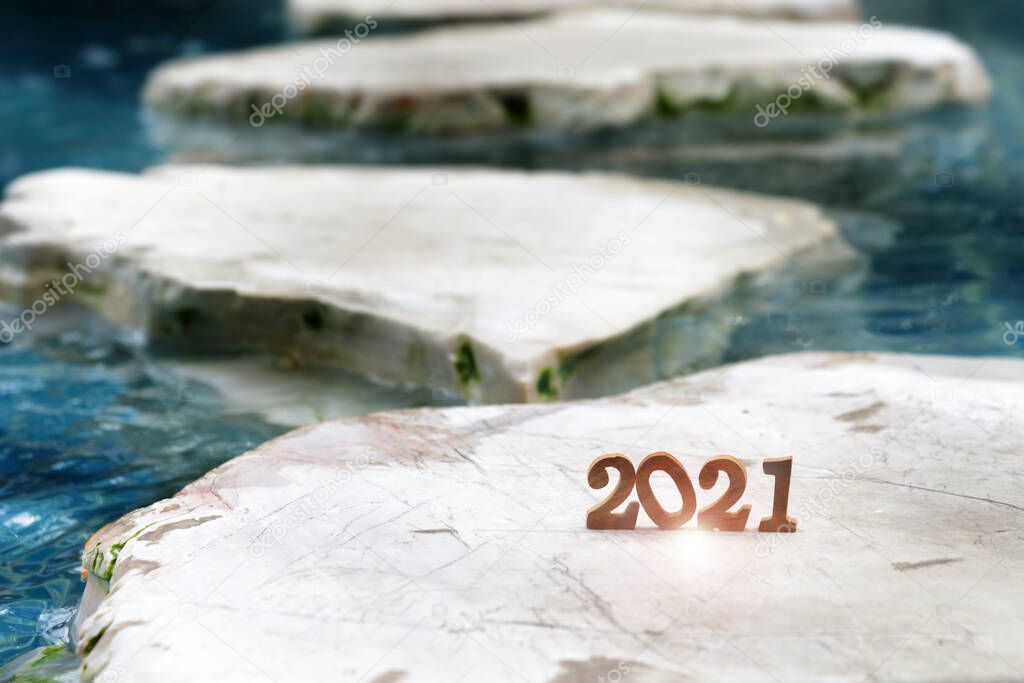 Wooden number 2021 on rock marble on pool background. Beginning challenge new year concept and business success idea