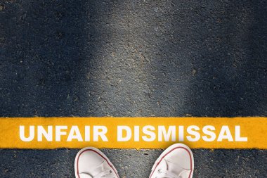 Asfalt yolda sarı çizgide yazılmış haksız işten çıkarma. Çalışanların işten çıkarılması ve ekonomik durgunluk fikri