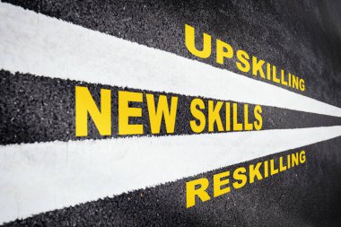 Yeni beceri geliştirme konsepti ve değişen beceri talep fikri. Beyaz çizgili asfalt yolda yeni yetenekler, yeniden öldürme ve yükseltme yazıları
