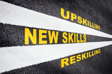 New skills development concept and changing skill demand idea. New skills, reskilling and upskilling written on asphalt road with white marking line clipart