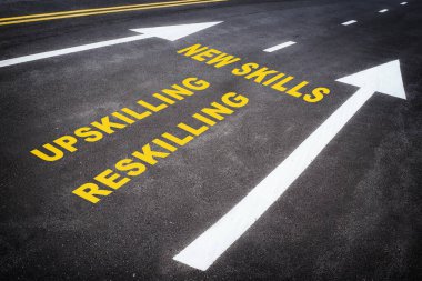 Newskills, upskilling and reskilling with white arrow sign marking on road surface for giving directions.  clipart
