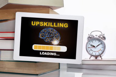 Upskilling loading with brain on digital computer tablet with stack of textbook with time to change words on alarm clock isolated on white background. Technology transformation concept and time management idea clipart