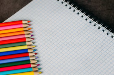 Boş beyaz defter ve koyu renkli kalem.