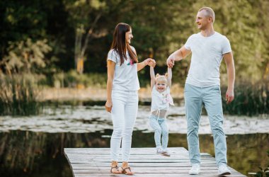 Mutlu genç aile parkta birlikte eğleniyor.