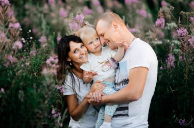 Parkta kızlarıyla birlikte eğlenen genç ve şirin ebeveynlerin görüntüsü. Yakın plan.