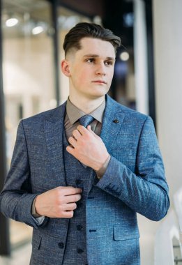 Yakışıklı erkek model mavi bir takım elbise poz.