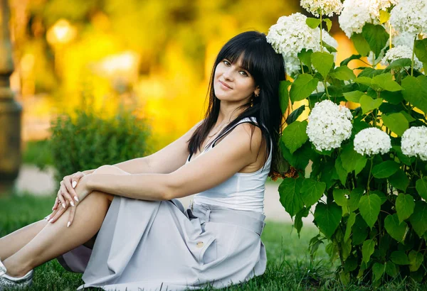 Piękna młoda kobieta na polanie wśród kwiatów — Zdjęcie stockowe