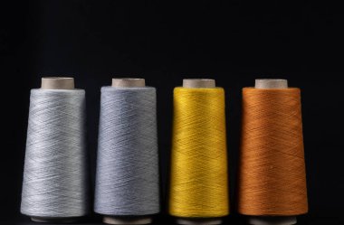 Siyah arkaplanda izole edilmiş renkli iplik parçaları