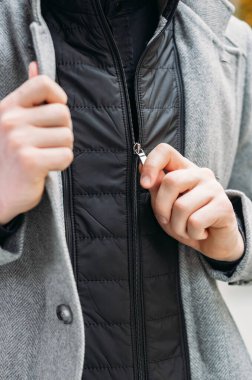 Ceketin düğmelerini açan elin yakın çekimi.