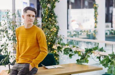 Kafedeki bir masanın yanında genç bir adamın portresi. Boşluğu kopyala.