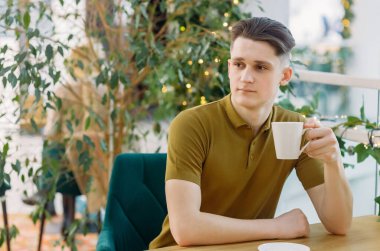 Kafede kahve içen yakışıklı adam..